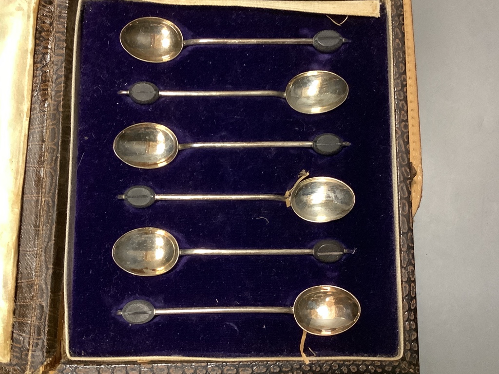 A cased pair of silver mounted clothes brushes, a cased silver spoon and pusher and a cased set a silver bean end coffee spoons.